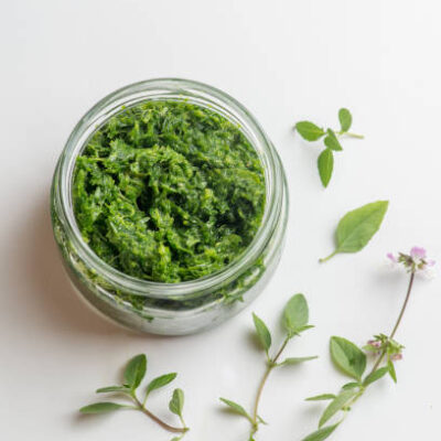 Pesto sauce in a jar on a white background