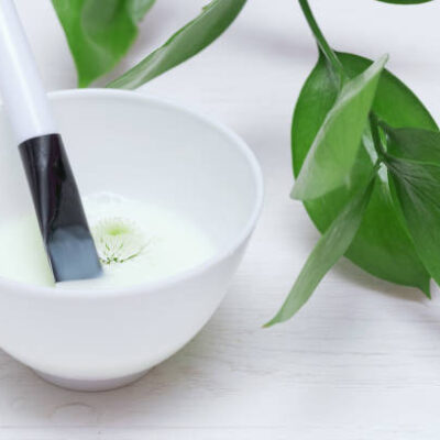 Natural cosmetic face mask in a jar on a white table background.